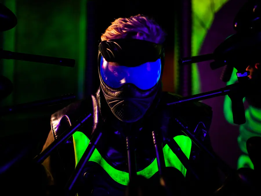 Spiller med maske og markør i paintballhallen